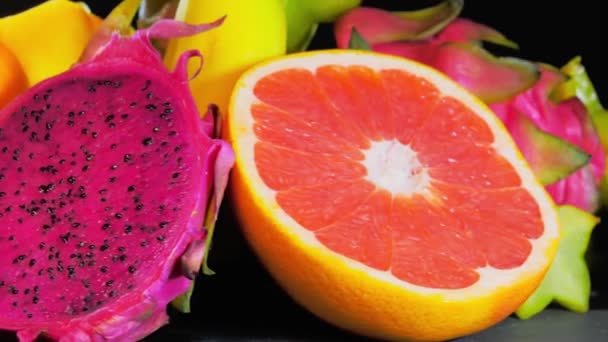 Exotiska färska frukter roterande på svart bakgrund — Stockvideo