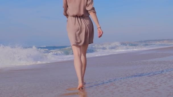 Mulher caminhando na praia de areia com ondas oceânicas — Vídeo de Stock