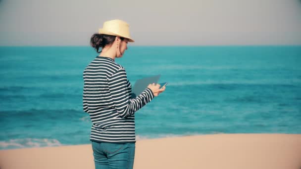 Mooie vrouw met laptop krijgt goed nieuws op het strand. — Stockvideo