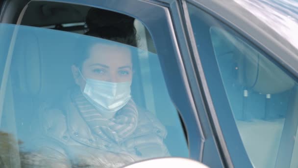 Femme en voiture avec masque chirurgical sur le visage ouvrant fenêtre de voiture. Coronavirus 2019 — Video