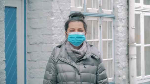 Kobieta na ulicy nosi maskę ochronną, wirus SARS-CoV-2. COVID-19 — Wideo stockowe