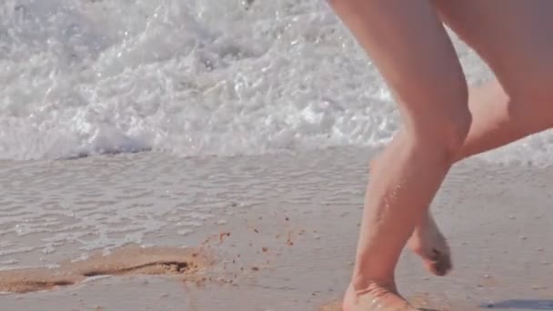 Donna che cammina sulla spiaggia, correndo in onde schiumose dell'oceano . — Video Stock