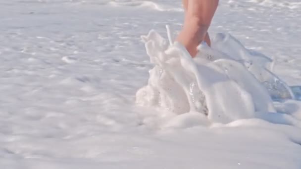 海岸を歩く女、海の泡の波. — ストック動画