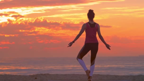 Kvinna utövar yoga på stranden, sommar solnedgång — Stockvideo