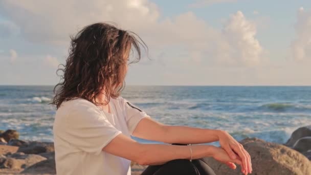 Junge Frau blickt am Strand in die Kamera — Stockvideo