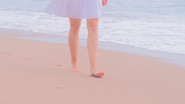 Пляжное путешествие, женщина в белых платьях, гуляющая по песчаному пляжу . — стоковое видео