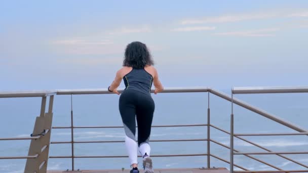 Mujer activa corredora en la orilla del mar haciendo ejercicios deportivos, fitness cross fit y concepto deportivo — Vídeo de stock
