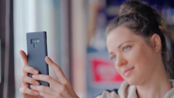 Jeune femme faisant selfie pour smartphone auto au café 