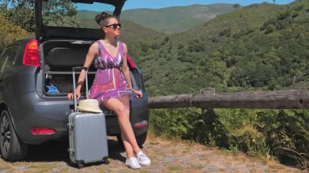 Bavullu bir kadın arabayla seyahat eder, yolculuklarını planlar. — Stok video