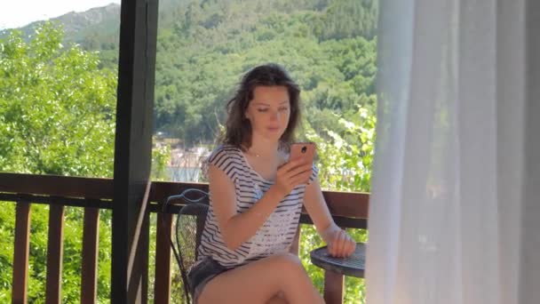 Frau auf Balkon mit Smartphone — Stockvideo