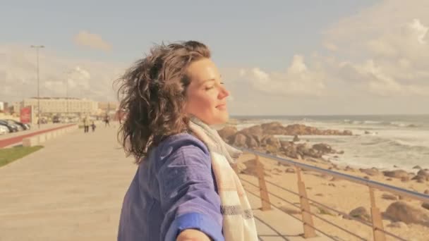 Женщина держит мужчину за руку на пляже у моря — стоковое видео