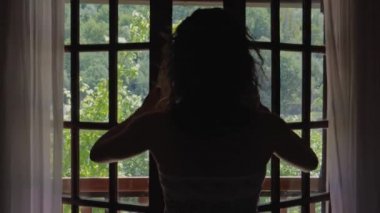 Yatak odasında Perdeleri ve Pencereyi açan kadın