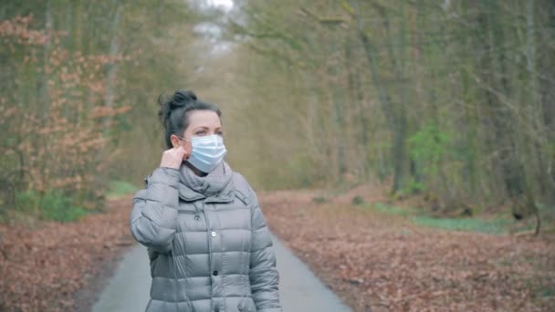 Kvinna tar bort skyddsmask från ansikte och leenden, upp med händerna — Stockvideo