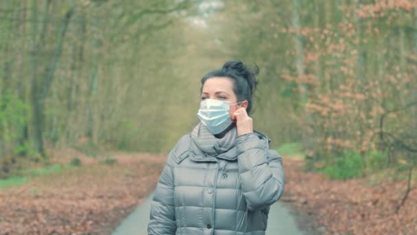 Mujer quita la máscara protectora de la cara y sonríe, Ella toma una respiración profunda — Vídeos de Stock