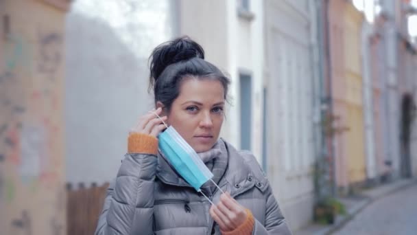Frau in Stadtstraße setzt Gesichtsschutzmaske auf — Stockvideo
