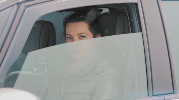 Mujer en la ventana de apertura del coche y mostrando el documento de pase, mirando a la cámara — Vídeo de stock