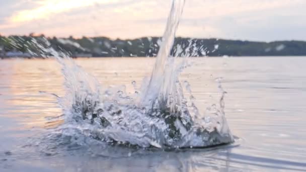 Water jet hits op het wateroppervlak, druppels bespoten — Stockvideo