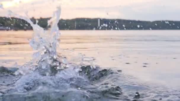 Water jet hits op het wateroppervlak, druppels gespoten over een meer — Stockvideo
