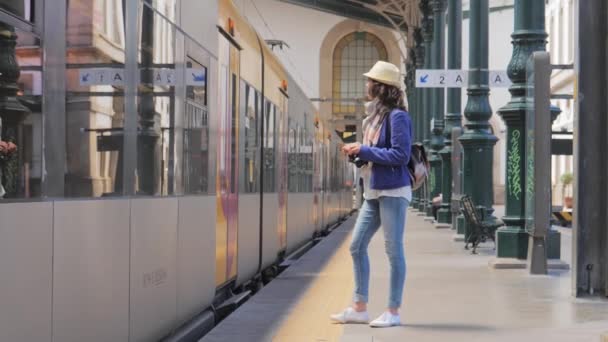 Пассажирка садится в поезд на вокзале — стоковое видео