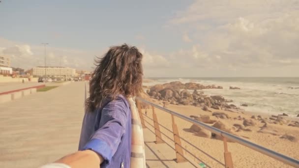 Mujer sosteniendo la mano masculina en la playa junto al mar, cámara lenta — Vídeo de stock