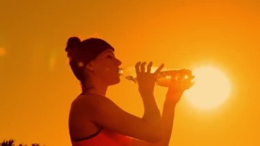 Çekici sporcu şişeden su içiyor.