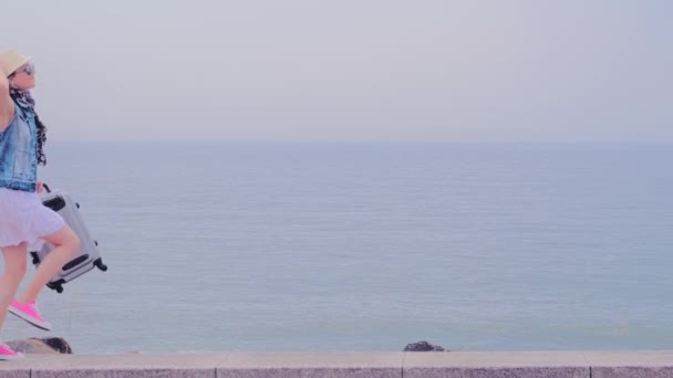 Gelukkig toeristisch wandelen met bagage op het strand — Stockvideo