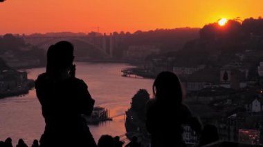 Dans eden insanlar anne ve kızı Douro nehrinde günbatımının tadını çıkarıyor.