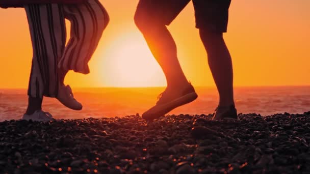 Erkek ve kadın gün batımında sahilde dans ediyor ve eğleniyorlar. — Stok video
