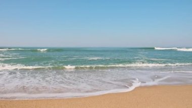 Kumsalda yumuşak bir mavi okyanus dalgası. .