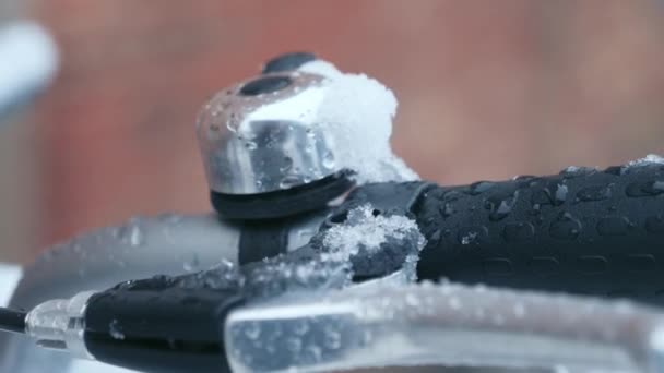 Fiets staat onder een stenen muur in de sneeuw in de winter, close-up — Stockvideo