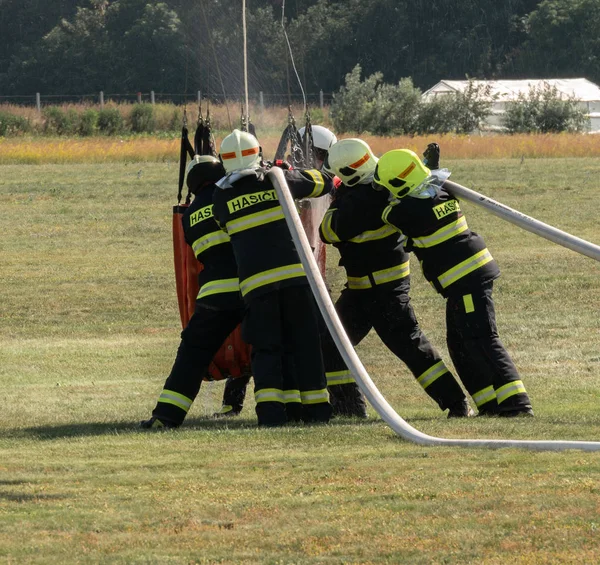 Firefighters filling water bucket under helicopter — ストック写真