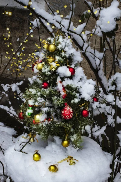 Pequeño árbol de Navidad con juguetes al aire libre en la nieve —  Fotos de Stock