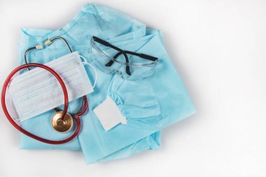 Tıbbi elbise, gözlük, maske, stetoskop. Coronavirus covid-19 salgınında ve cerrahi operasyonlar sırasında bir doktor ve tıbbi personelin kişisel güvenliği için tıbbi tesisler