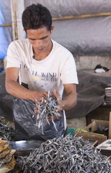 Hombre indonesio vendiendo pescado seco en el mercado —  Fotos de Stock