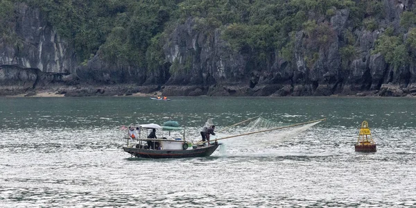 Uomo in barca pesca in barca a Halong Bay — Foto Stock