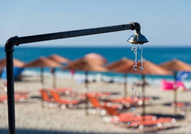 Shower pouring water at the Agios Ioannis beach in the area of Mount Pelion in Greece in summer clipart