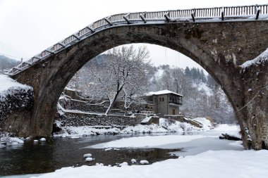 Yunanistan 'ın Epirus kentindeki Vovousa köyündeki geleneksel taş köprüye kışın manzara
