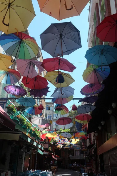 Маленькая улица, украшенная плавающими красочными зонтиками — стоковое фото