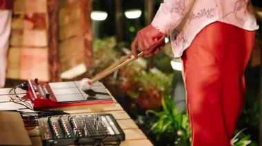 Elektronik davul çalan adam. Elleri ve sopaları görüyoruz..