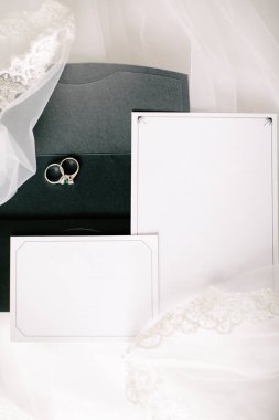 Düğün ya da nişan davetiyesi. Boş beyaz yazı alanı. Evlilik yüzükleri. Zeminde tulle.