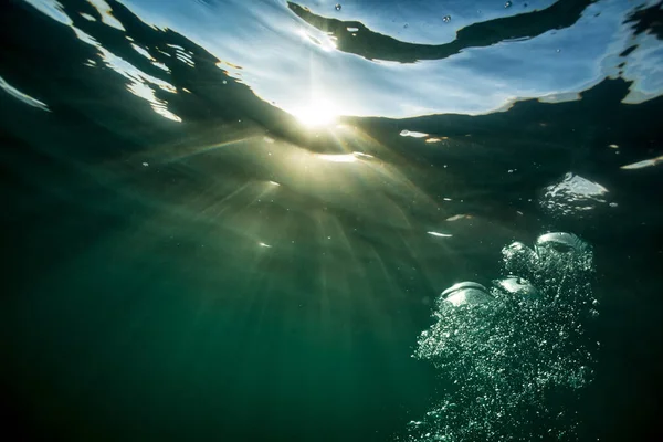 Lumière du soleil à travers la surface de l'eau — Photo