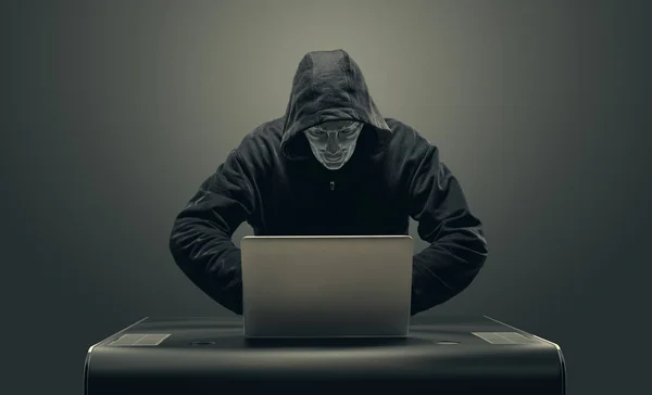 Hacker in maschera dal computer portatile — Foto Stock