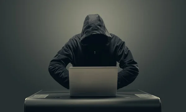 Hacker in maschera dal computer portatile — Foto Stock