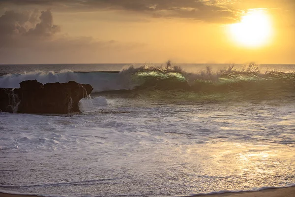 Sonnenuntergangswelle kracht auf einen Strand — Stockfoto