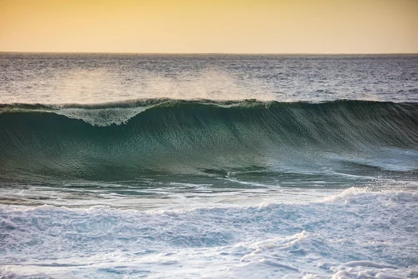 Tramonto onda schiantarsi su una spiaggia — Foto Stock