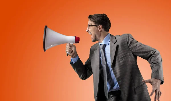 Businessman in gray suit with megaphone — Stock Photo, Image