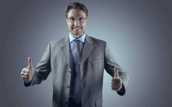 Podnikatel v šedém obleku s úsměvem a oba palce nahoru — Stock fotografie