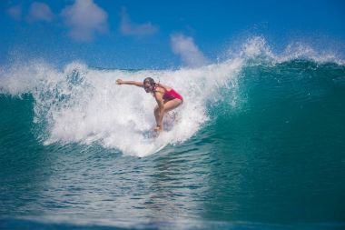 Endonezya, Bali, 23 Temmuz 2016: Bir kadın sörfçü, Leonor büyük mavi okyanus sörf dalga sürme Fragoso su seviyesinden vurdu