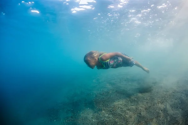 かわいい子供の海の水が青い背景で水中撮影で金髪少女 — ストック写真