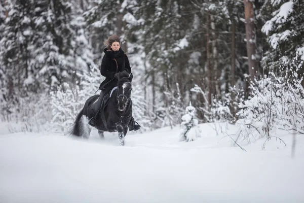 Een Meisje Rijdt Zwart Paard Door Sneeuw Winter Bos Achtergrond — Stockfoto